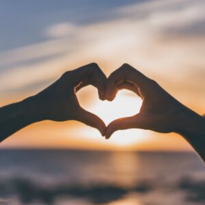 Couple overcomes relationship resilience and makes a heart from their hands.